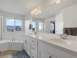 Primary bathroom featuring a stall shower, double vanity, a bath, and light tile patterned floors