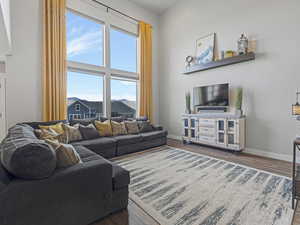 Living room featuring dark wood finished floors and baseboards