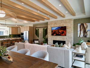Living area featuring beam ceiling, wallpapered walls, recessed lighting, and a fireplace