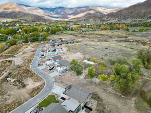 Aerial view of property and surrounding area featuring a mountainous background