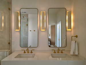 Full bath featuring double vanity and a shower with shower door