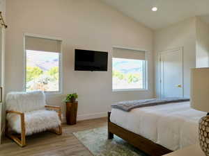 Bedroom featuring light wood-type flooring, vaulted ceiling, and recessed lighting