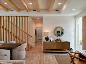 Entrance foyer featuring beamed ceiling, recessed lighting, light wood finished floors, and stairs