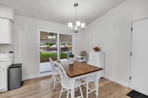 Dining area with light wood-style flooring and a chandelier