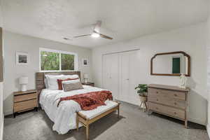 Bedroom featuring carpet flooring, a closet, a ceiling fan, and a textured ceiling