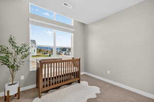 Bedroom featuring a nursery area, carpet floors, and a mountain view