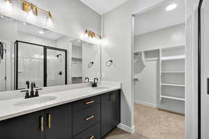 Full bathroom featuring a walk in closet, a stall shower, double vanity, recessed lighting, and light tile patterned floors