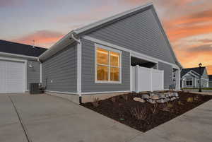 Property exterior at dusk featuring driveway and an attached garage