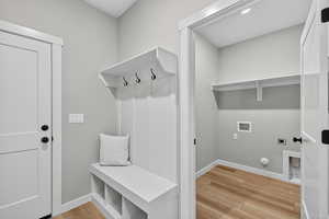 Laundry area featuring light wood-type flooring, hookup for a washing machine, hookup for a gas dryer, and hookup for an electric dryer