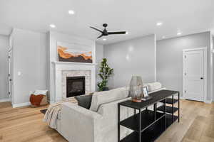 Living room featuring light wood finished floors, recessed lighting, a ceiling fan, and a high end fireplace