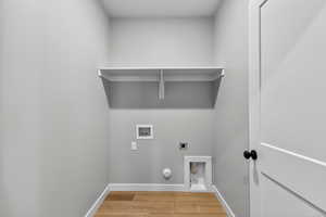 Laundry room featuring electric dryer hookup, hookup for a washing machine, light wood-type flooring, and gas dryer hookup