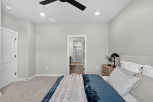 Bedroom with light colored carpet, ensuite bathroom, recessed lighting, and ceiling fan