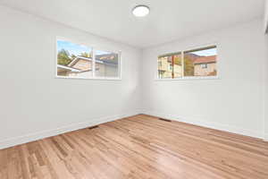 Unfurnished room featuring light wood-style flooring and baseboards bedroom 1 of 3 on main floor
