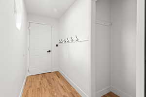 Entryway with wood finished floors and baseboards coming in from garage