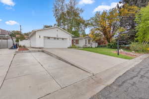 Ranch-style house featuring a garage and concrete driveway