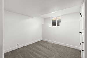 Carpeted empty room with baseboards