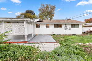 Rear view of property with a deck and a shingled roof