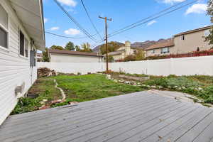 Wooden deck with a fenced backyard