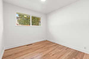 Spare room featuring light wood finished floors and baseboards
