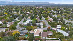 Aerial view of property and surrounding area featuring nearby suburban area and mountains
