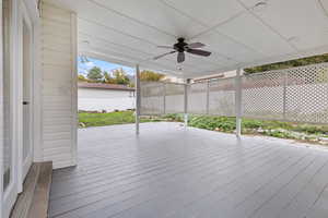 Wooden deck featuring a fenced backyard and ceiling fan