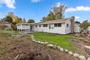 Back of property featuring a chimney and roof with shingles