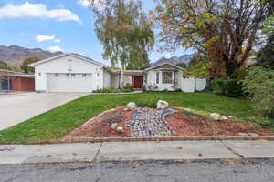 Single story home with a mountain view, concrete driveway, and a garage