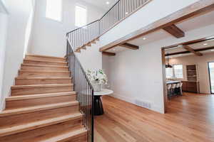 Stairs with wood finished floors and recessed lighting