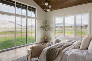 Primary bedroom suite on main level with expansive windows offering natural light