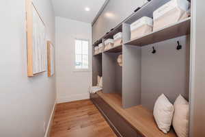 Mudroom just off garage with bench seating, hooks, and more storage