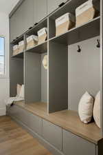 Built-in mudroom cabinetry featuring overhead storage with black hardware (located just off garage)