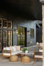 Spacious outdoor patio featuring concrete flooring, a paneled ceiling, and stone pillar accents