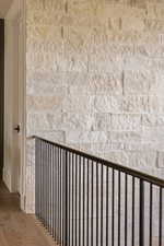 Textured stone wall accentuating a modern black metal railing