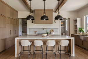Grandiose chef's kitchen with marble waterfall island, paneled refrigerator and freezer, gas-range and butlers pantry.