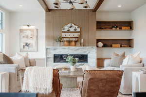 Living room featuring a high end fireplace, built-in storage and open shelving with all the right blend of finishes