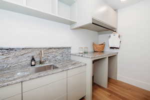 Upstairs laundry room with sink, built-in cabinets and folding counter