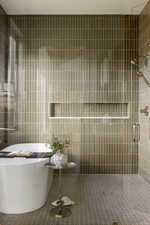 Bathroom featuring a freestanding tub and a walk-in shower with a glass enclosure