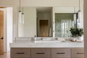 Dual vanity featuring a white countertop with subtle veining, undermount sinks, and brass-finish faucets