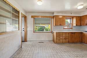 Kitchen featuring light countertops, brown cabinetry, and light floors