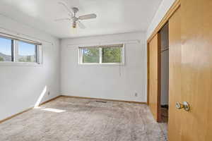 Unfurnished bedroom with a closet, a ceiling fan, and carpet
