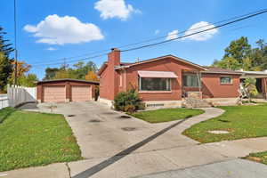 Single story home with an outdoor structure, brick siding, a chimney, a garage, and entry steps