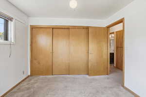Unfurnished bedroom with a closet and light carpet