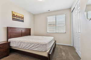 Carpeted bedroom with a closet and a textured ceiling