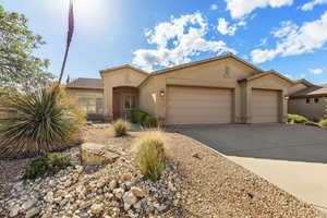View of front of home featuring an attached garage, stucco siding, and driveway