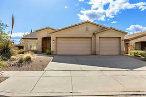 Ranch-style home featuring stucco siding, concrete driveway, a garage, and a tile roof