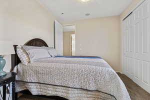 Bedroom with carpet, a closet, and a textured ceiling