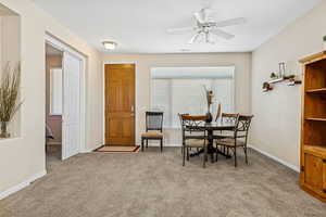 Dining area featuring light carpet, a ceiling fan, and a textured ceiling