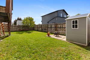Fenced backyard featuring a shed and a patio area