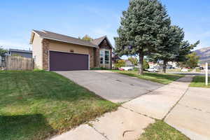 View of front of home with concrete driveway, brick siding, and an attached garage