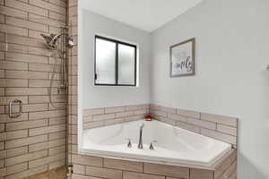 Full bathroom with a shower stall and a garden tub